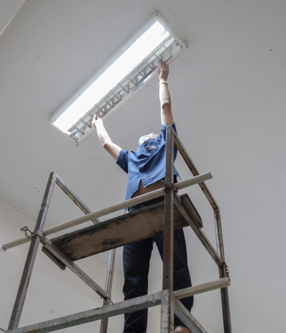 electrician installing fluorescent lighting